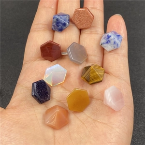 Primer plano de piedras naturales hexagonales facetadas de colores en la mano