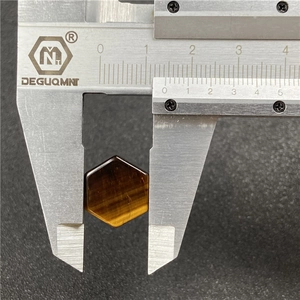 Medición detallada de una piedra ojo de tigre hexagonal de 15 mm con un calibrador