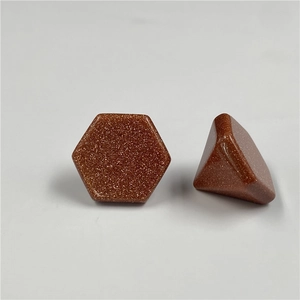 Detalle de piedras piramidales hexagonales de goldstone rojo con brillo metálico