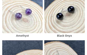 Details von Amethyst- und Onyx-Ohrringen auf natürlichen Holzscheiben präsentiert