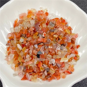 Cristaux d'agate rouge polie et pierres de cornaline dans un bol en coquillage blanc