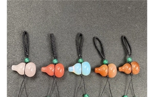 Detailed close-up of five colored crystal gourd keychains with black woven cords