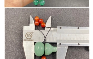 Detailed size measurement of the green jade gourd pendant with ruler showing dimensions