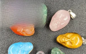 Detailed view of hand-carved crystal skull pendants made from various semi-precious stones