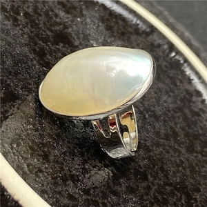 Detail shot of large oval mother-of-pearl cabochon on wide silver vintage ring band
