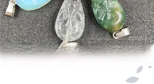 Macro detail of hand-carved crystal skull pendants in agate and tiger eye stone