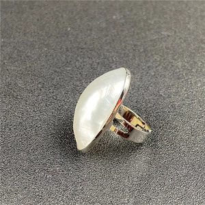 Detail of silver hollow ring featuring a large marquise-shaped white mother of pearl stone