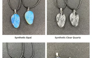 Detailed view of hand-carved skull pendants in opalite and clear quartz with cords