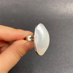 Detail view of oval white mother of pearl ring with silver split-shank open band design