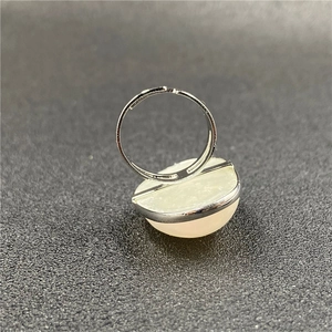 Macro shot of silver minimalist open ring with a translucent pink mabe pearl setting
