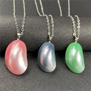 Trois colliers de perles en forme de haricot rose, bleu et vert sur support sombre