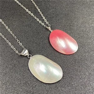 Vue détaillée de colliers ovales en nacre rose et verte avec un éclat nacré naturel