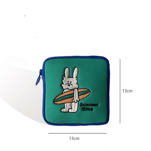 Close-up of 13x13cm green pouch with summer rabbit embroidery and blue zipper detail