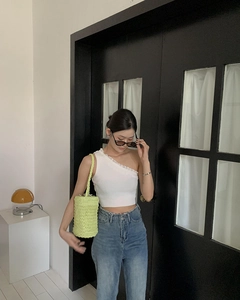 Detailaufnahme einer grünen Häkel-Strohtasche kombiniert mit einem schicken Sommeroutfit
