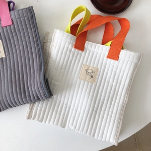 Detail showing quilted cotton tote bags with contrast handles and cute sheep patch