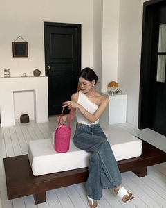 Magenta Stroh-Eimertasche mit rosa Kordelzug-Futter, am Modell in lässiger Umgebung