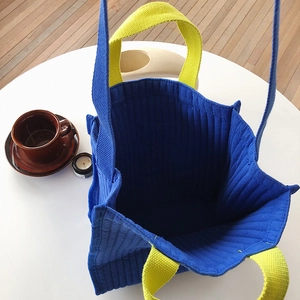 Top view of large quilted canvas tote bag showing spacious blue interior and yellow straps