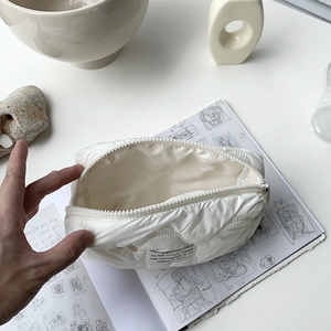 Quilted white cosmetic bag with bunny embroidery and zipper for travel storage