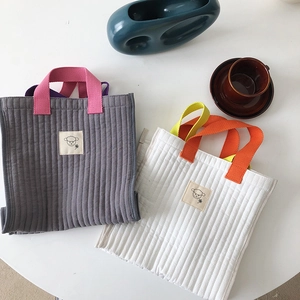 Quilted canvas tote bag with contrast handles and minimalist sheep patch detail