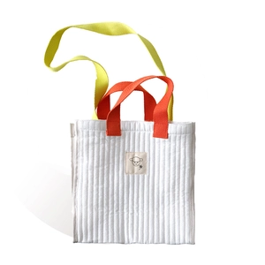 Quilted white canvas tote bag with colorful handles and a cute cartoon sheep logo