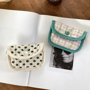 Detailed view of quilted floral coin purses with snap closure on a wooden desk