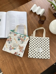 Détail de trousses à maquillage matelassées avec oursons et motifs à pois sur bois