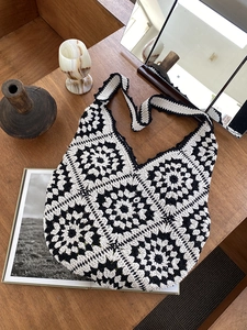 Detailed view of a hand-knitted crochet tote bag with black and white retro floral patterns