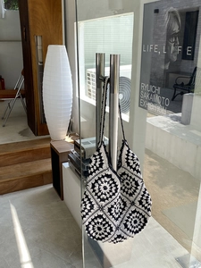Detail view of a handmade crochet tote bag with black and white granny square patterns