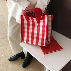 Detail of red and white vichy check tote bag with durable wide fabric handles
