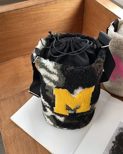 Detailed macro view of camo fleece bucket bag showing soft texture and M letter patch