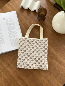 Détails d'un sac à main matelassé aux motifs floraux vintage avec poignée tissée