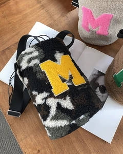 Detailed view of plush bucket bags with towel embroidered M and adjustable straps