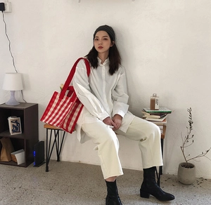 Red plaid canvas tote bag styled with a minimalist white shirt and cream trousers