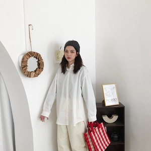 Detailed view of a white oversized long-sleeve cotton shirt with a classic turn-down collar