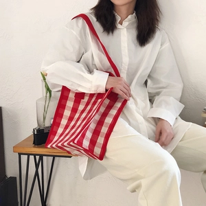 Detail of red gingham tote bag featuring canvas fabric and sturdy shoulder straps