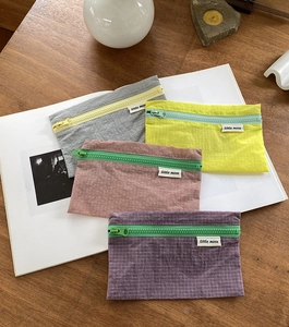 Details von vier bunten karierten Nylon-Aufbewahrungstaschen mit Reißverschluss auf Holz