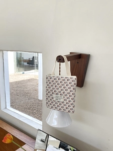 Sac à main matelassé en coton avec imprimé trèfle fleuri suspendu sur un support en bois
