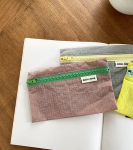 Makroaufnahme von Gitter-Nylon-Reisetaschen in Pastellfarben mit Kontrast-Reißverschlüssen