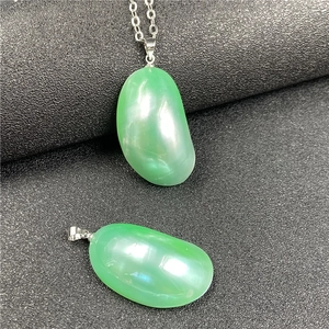 Détail macro de pendentifs en forme de haricot vert avec finition polie translucide