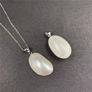 Détail des pendentifs élégants en nacre mabe irisée avec bordure en métal argenté