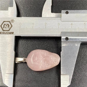 35mm hand-carved rose quartz skull pendant with silver metal bail on black background