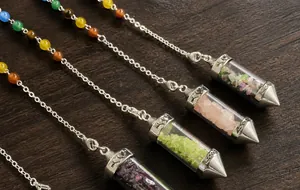 Close-up of glass hexagonal prism pendants filled with colorful natural crystal chips