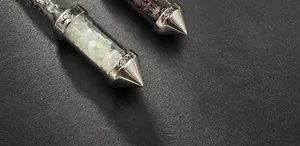 Macro detail of crystal gravel pendants with LOVE engraving and metal heart motifs