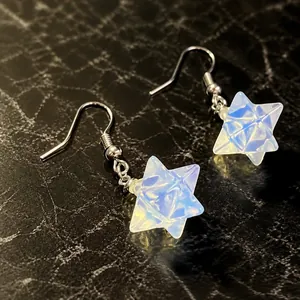 Detail view of milky white opal merkaba star earrings with silver hooks for women