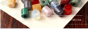 Close-up of polished natural gemstone cylinder beads including agate and amethyst for DIY