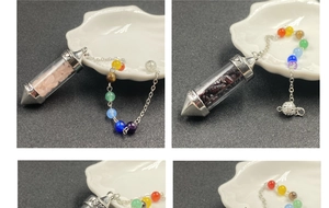 Detail of colorful crystal gravel pendant with heart love engraving and chakra beads