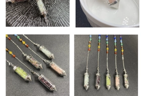 Detail showing 7 chakra crystal pendulum with multi-colored stones and silver love charm