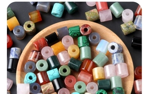 Detailed close-up of mixed natural stone cylinder beads and agate charms for DIY jewelry
