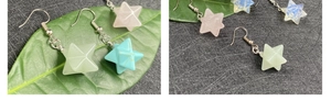 Detailed view of colorful star-shaped Merkaba crystal earrings with silver ear hooks