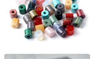 Macro detail of cylindrical gemstone beads including malachite, agate, and quartz stack